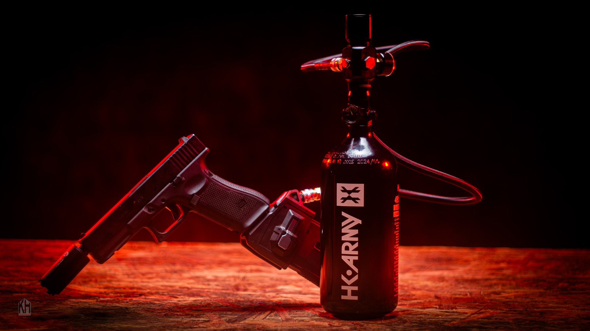 G17 airsoft hire pistol with HPA tank, regulator and hose under red lighting
