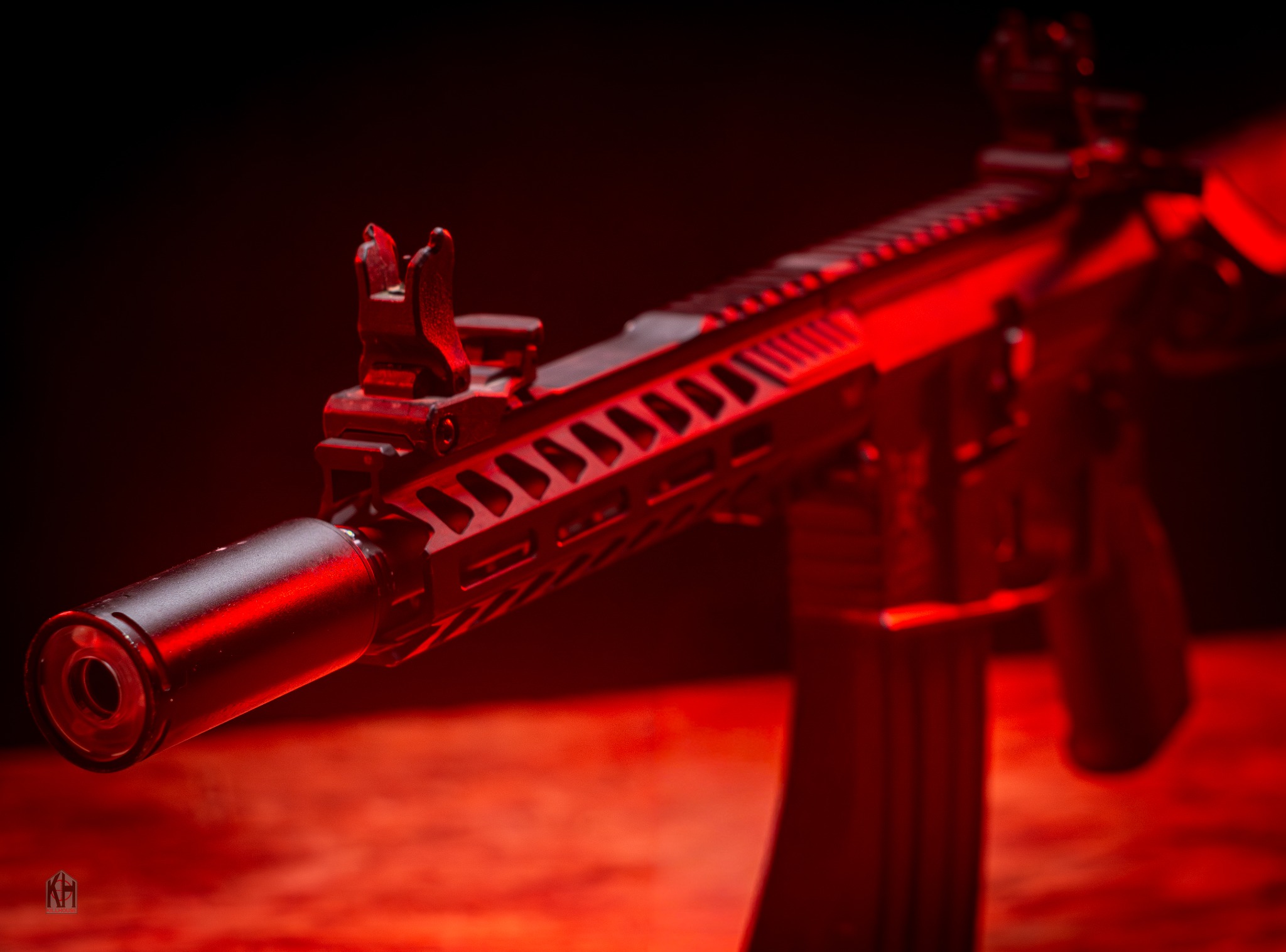 Premium airsoft hire rifle with tracer equipment under red lighting